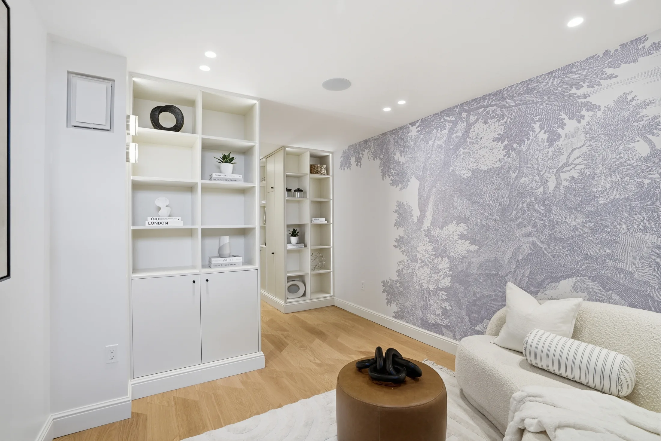 Lower-level library with built-in shelving and mural wallcovering at Casa Ulivo