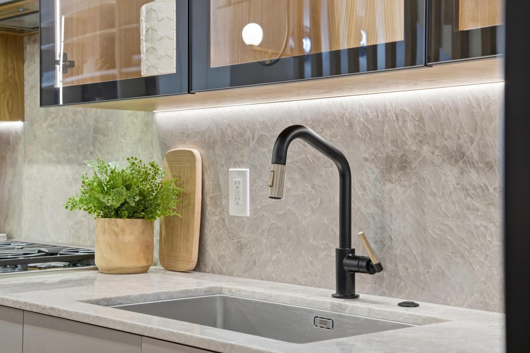 Backlit stone backsplash and black faucet at Casa Ulivo