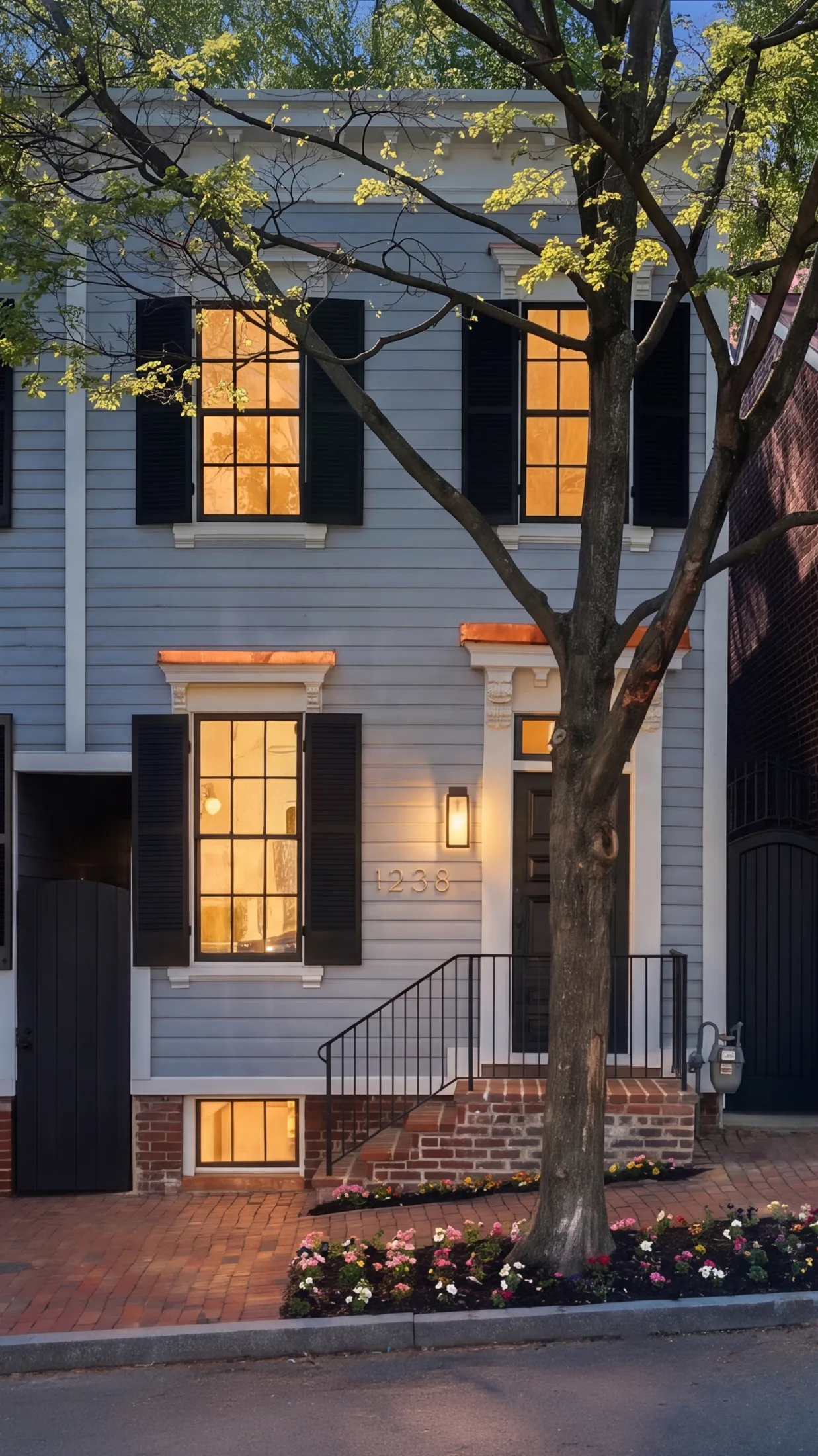 Casa Ulivo façade at dusk with lit windows and black shutters